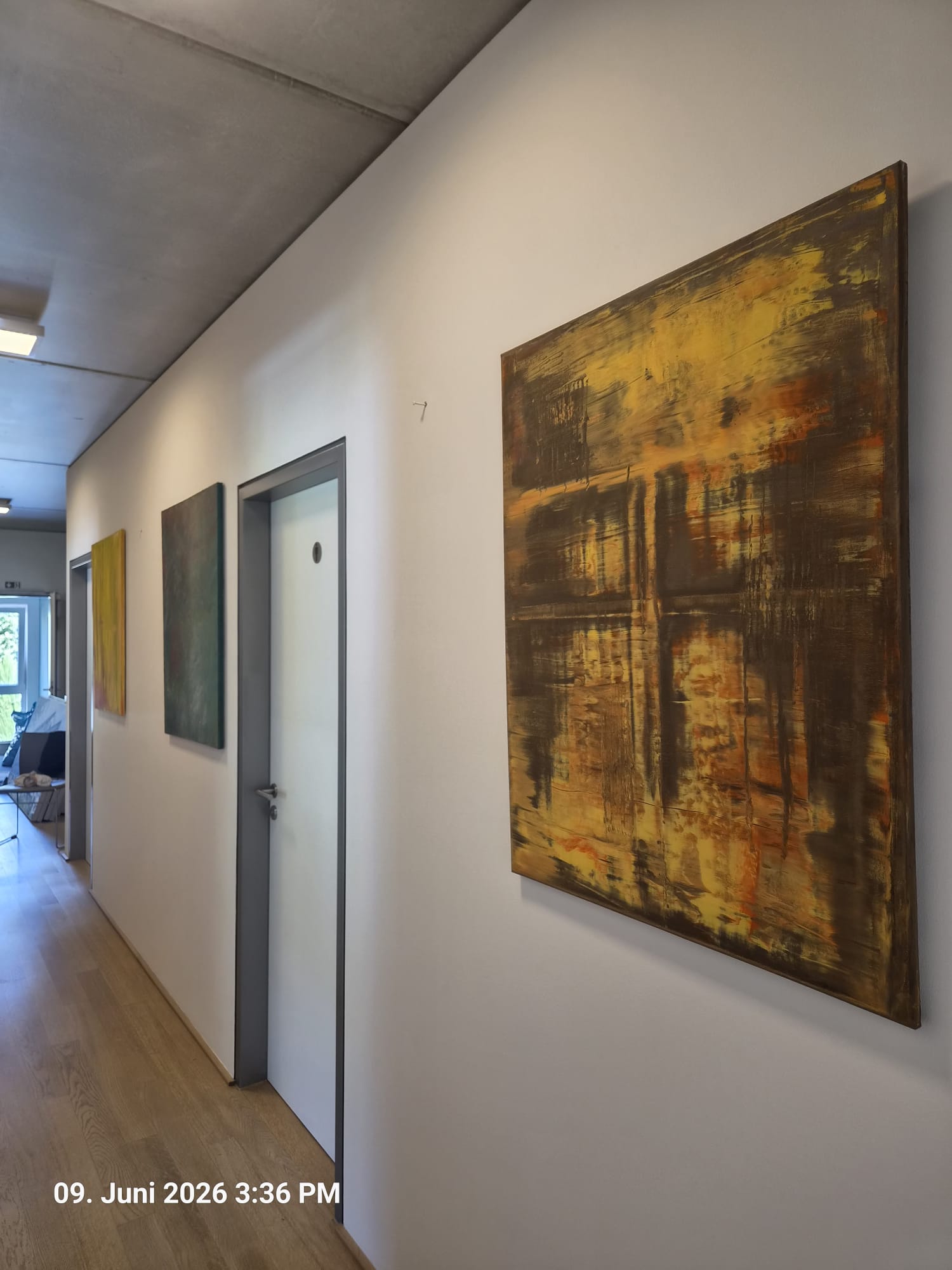 Ein heller Flur mit drei Werken, vorn „Lumière dans l’ombre“ in Gold und Schwarz