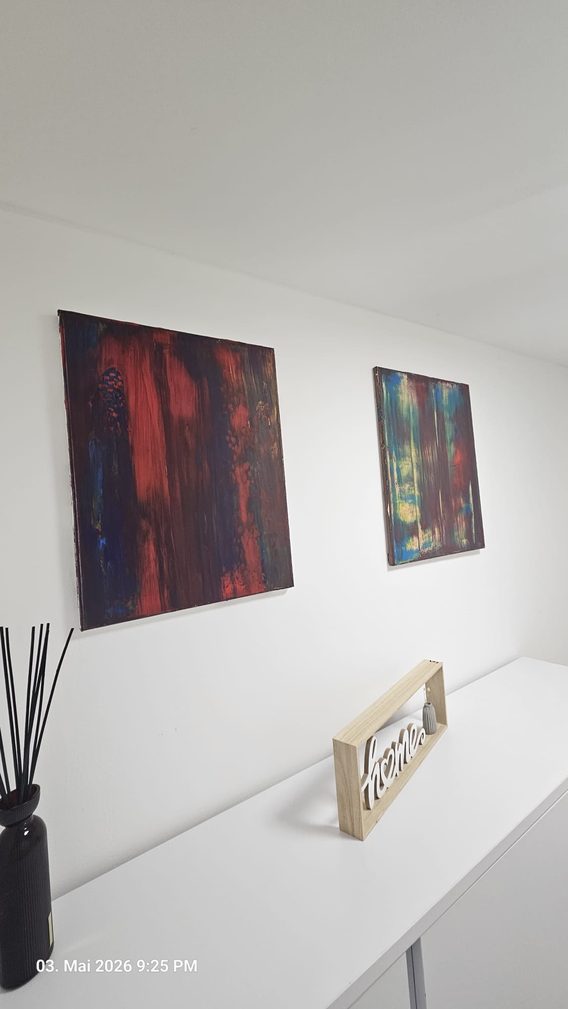 Zwei Werke in Rot, Blau und Türkis über einem weißen Sideboard
